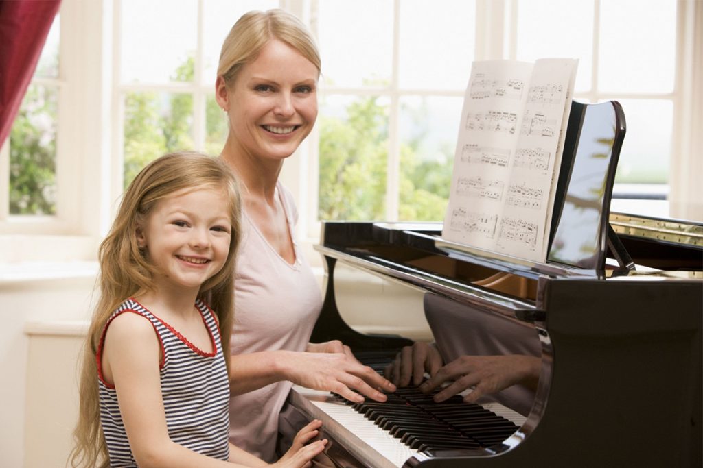 мама и дочь играют на пианино