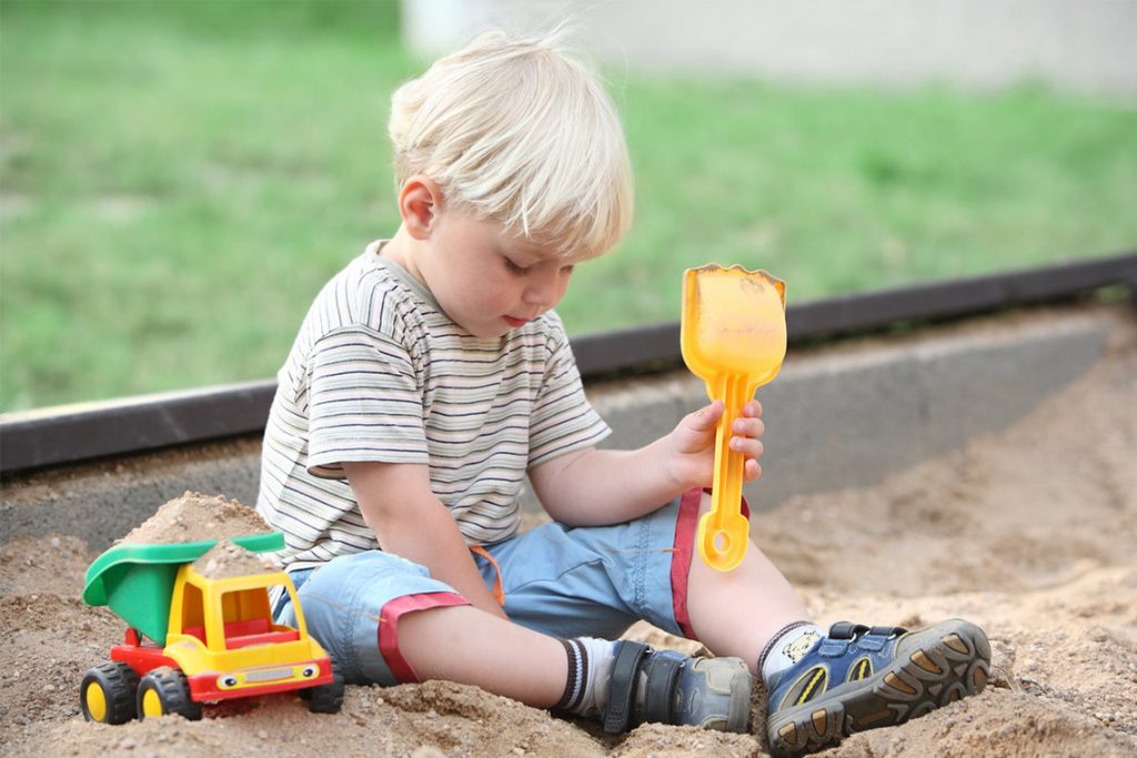 малыш играет в песочнице