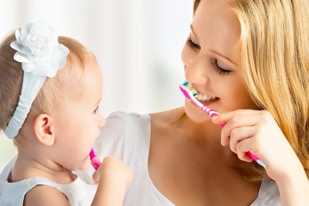мама с дочкой чистит зубы