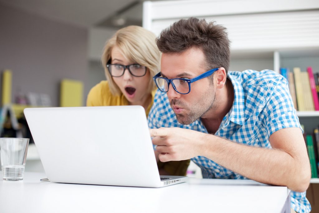 мужчина с женщиной шокировано смотрят в ноутбук 