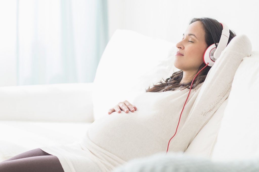 беременная девушка слушает музыку