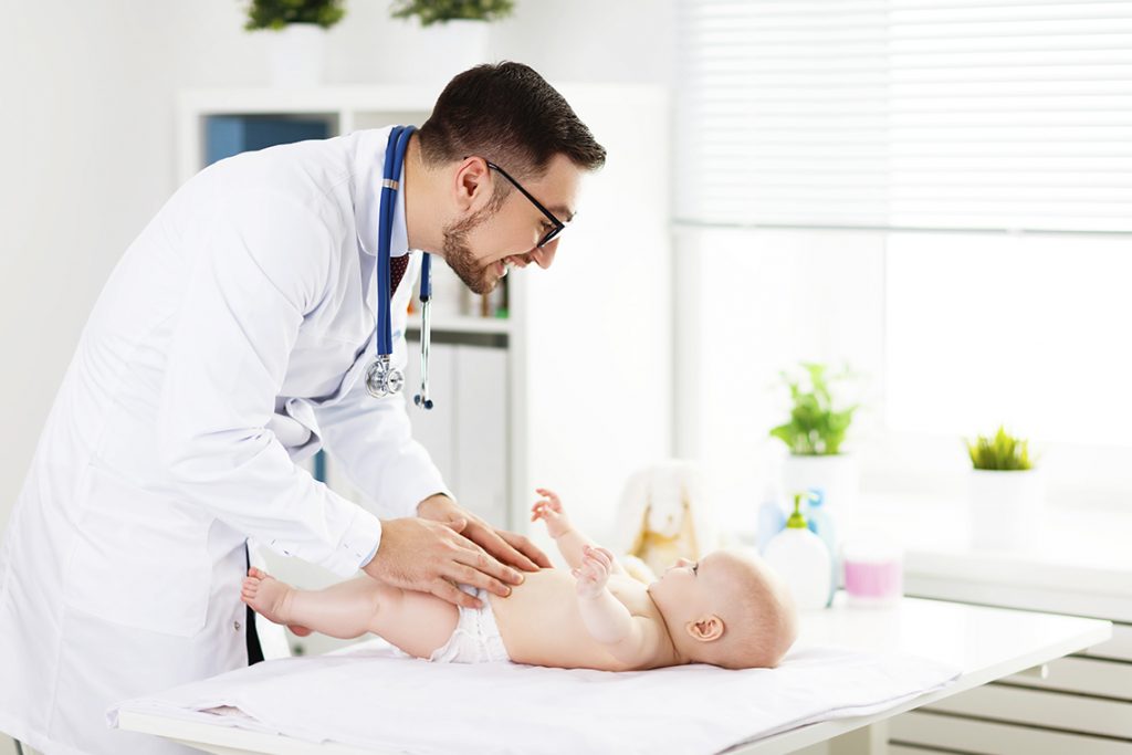 мужчина врач осматривает малыша